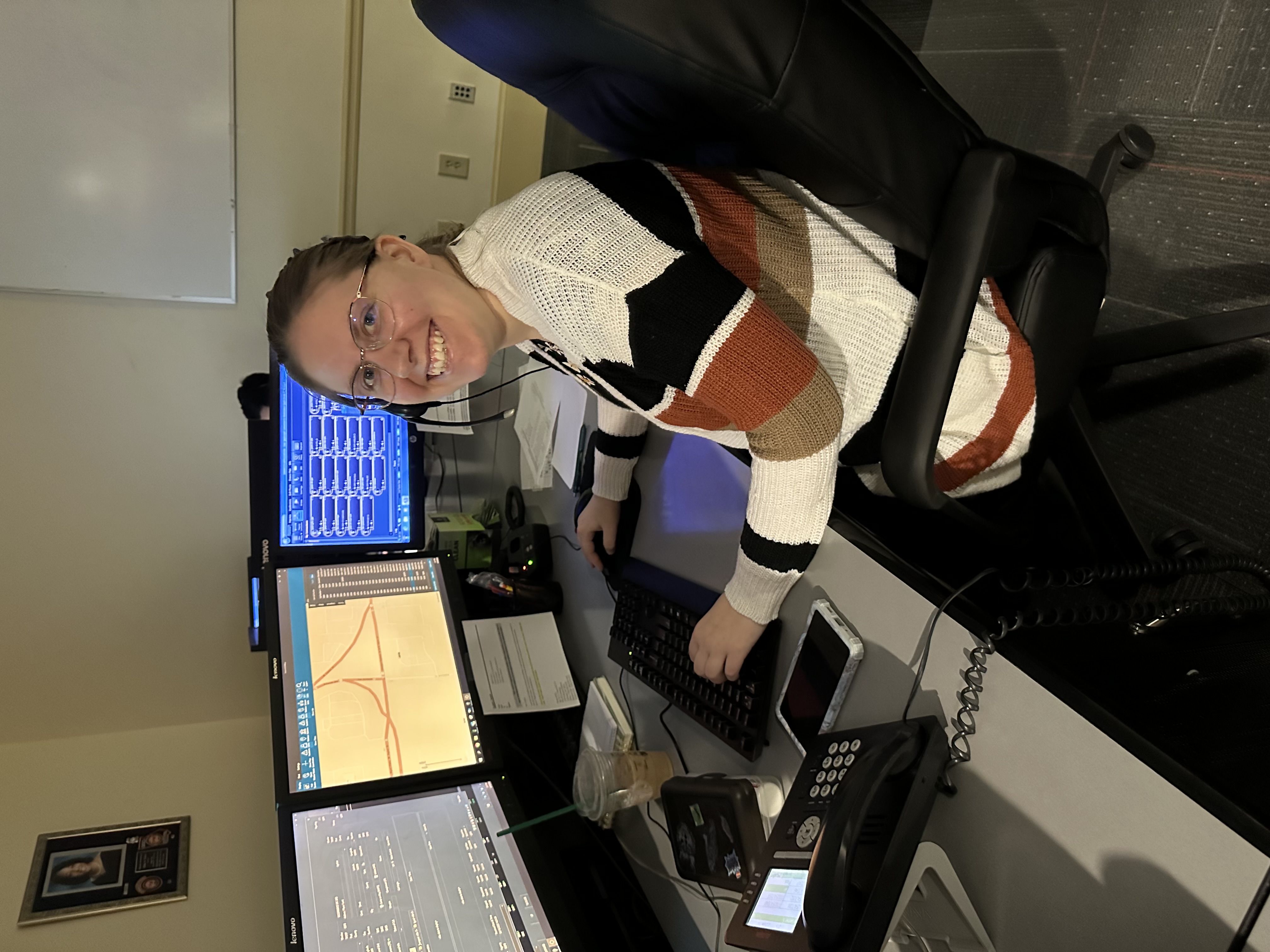 DPS dispatcher smiling at workstation with multiple monitors