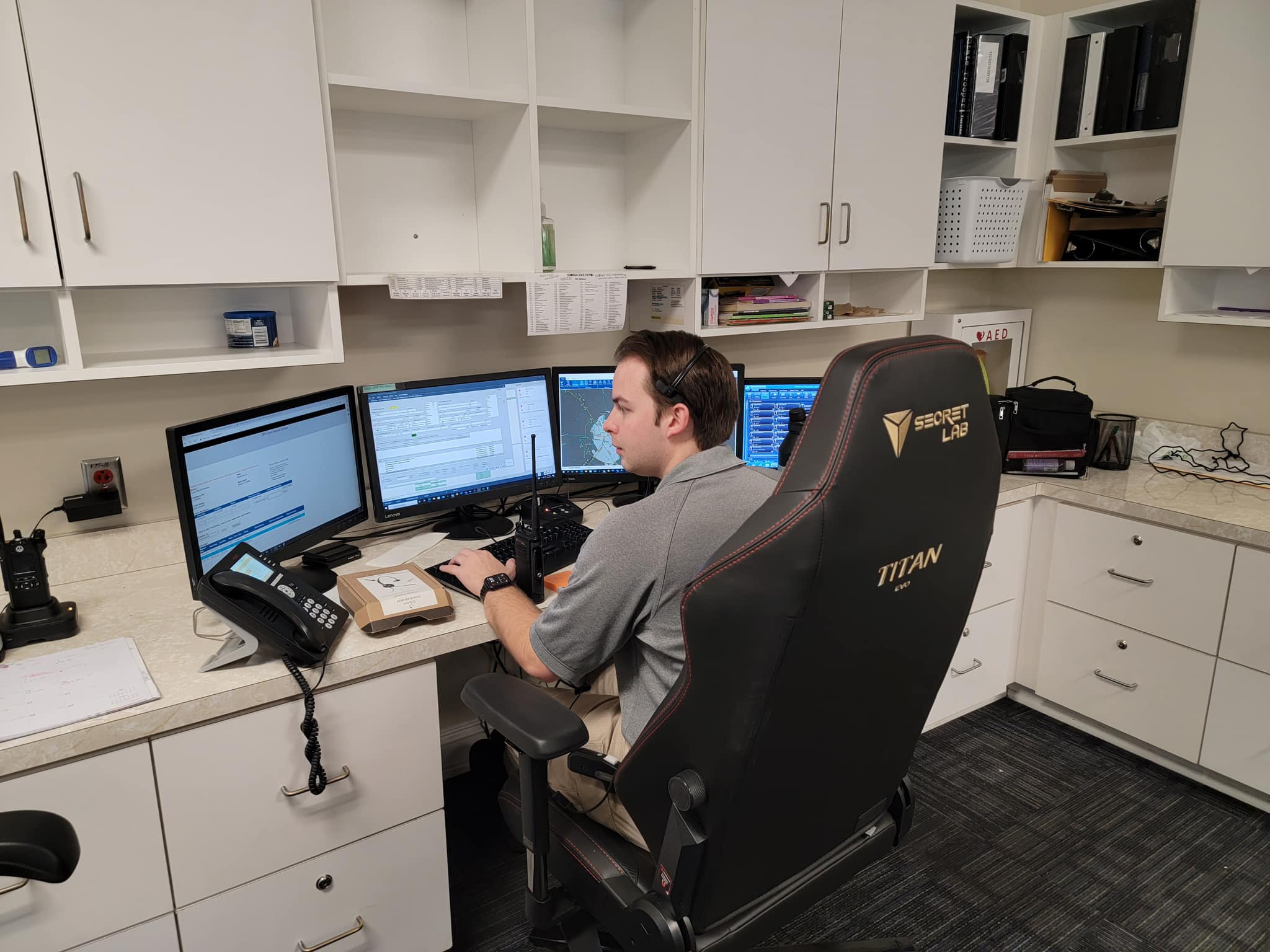 DPS communications center with dispatcher at multi-screen workstation and Georgia troop map on the wall